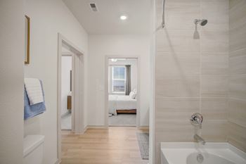 A bathroom with a white tub and a window.